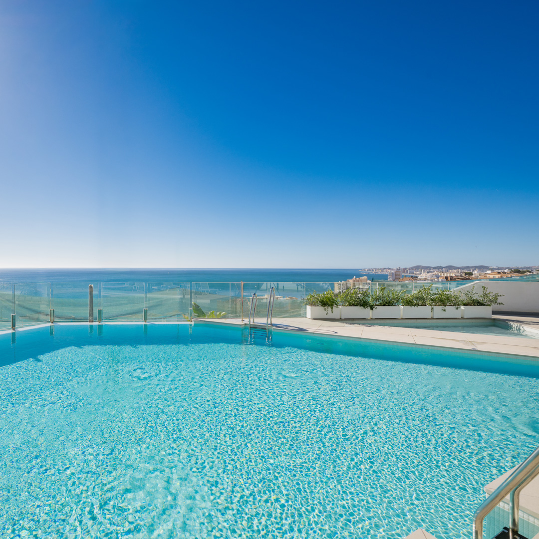 Piscina en amplia terraza luminosa con vista en el mar y en la costa