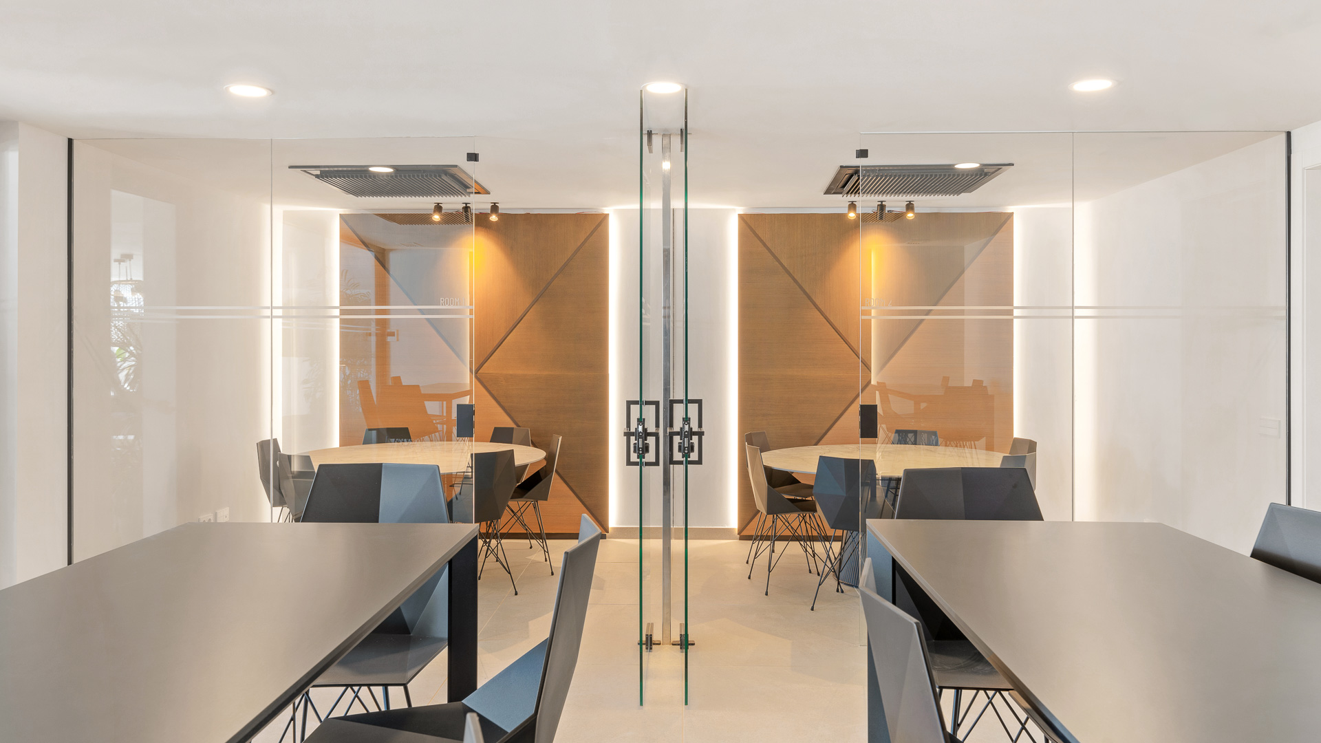 Espacio de coworking acristalado con mesas de trabajo y sillas.