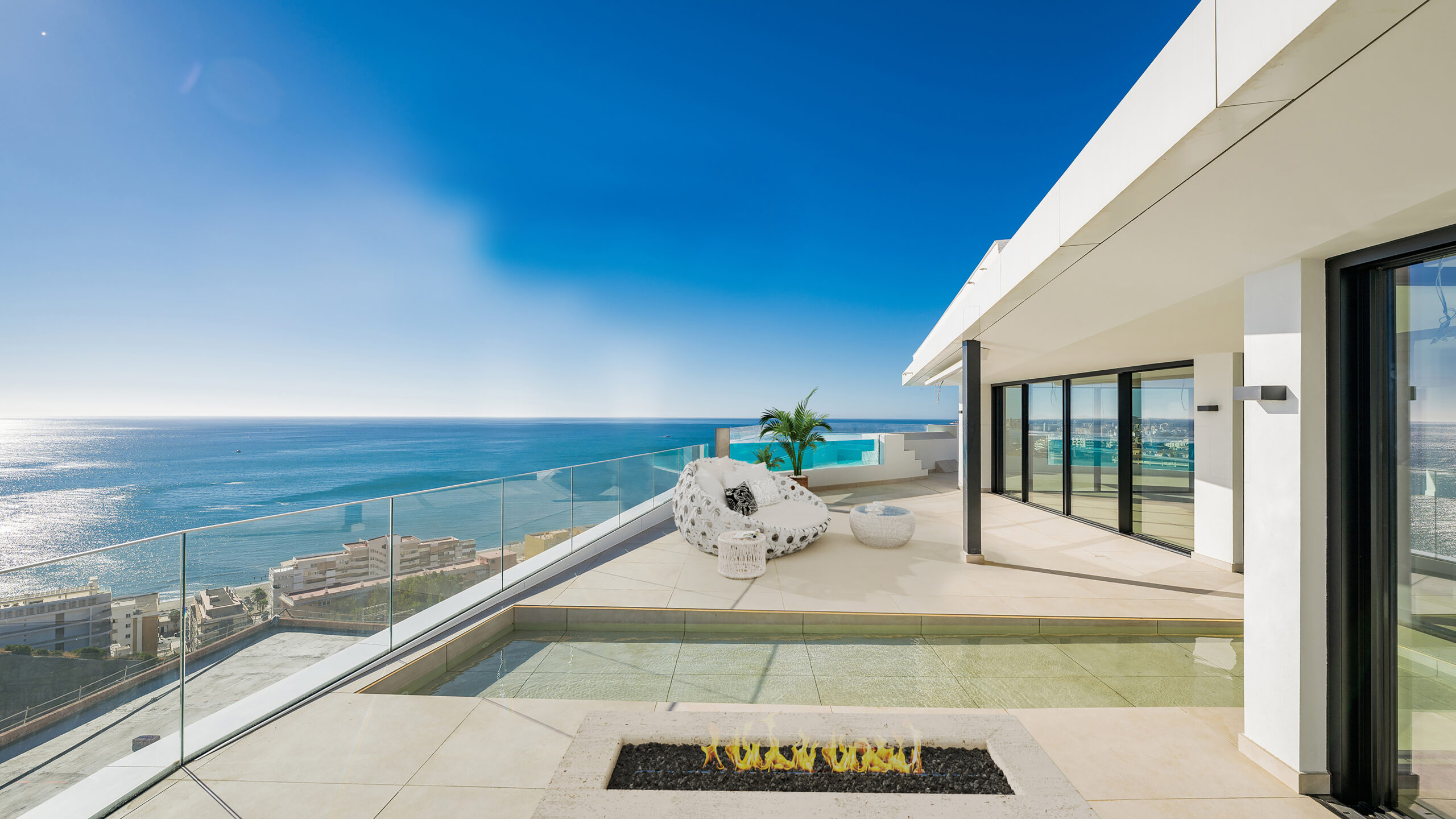 Terraza con piscina privada, zona de relax y vistas panorámicas al mar Mediterráneo.