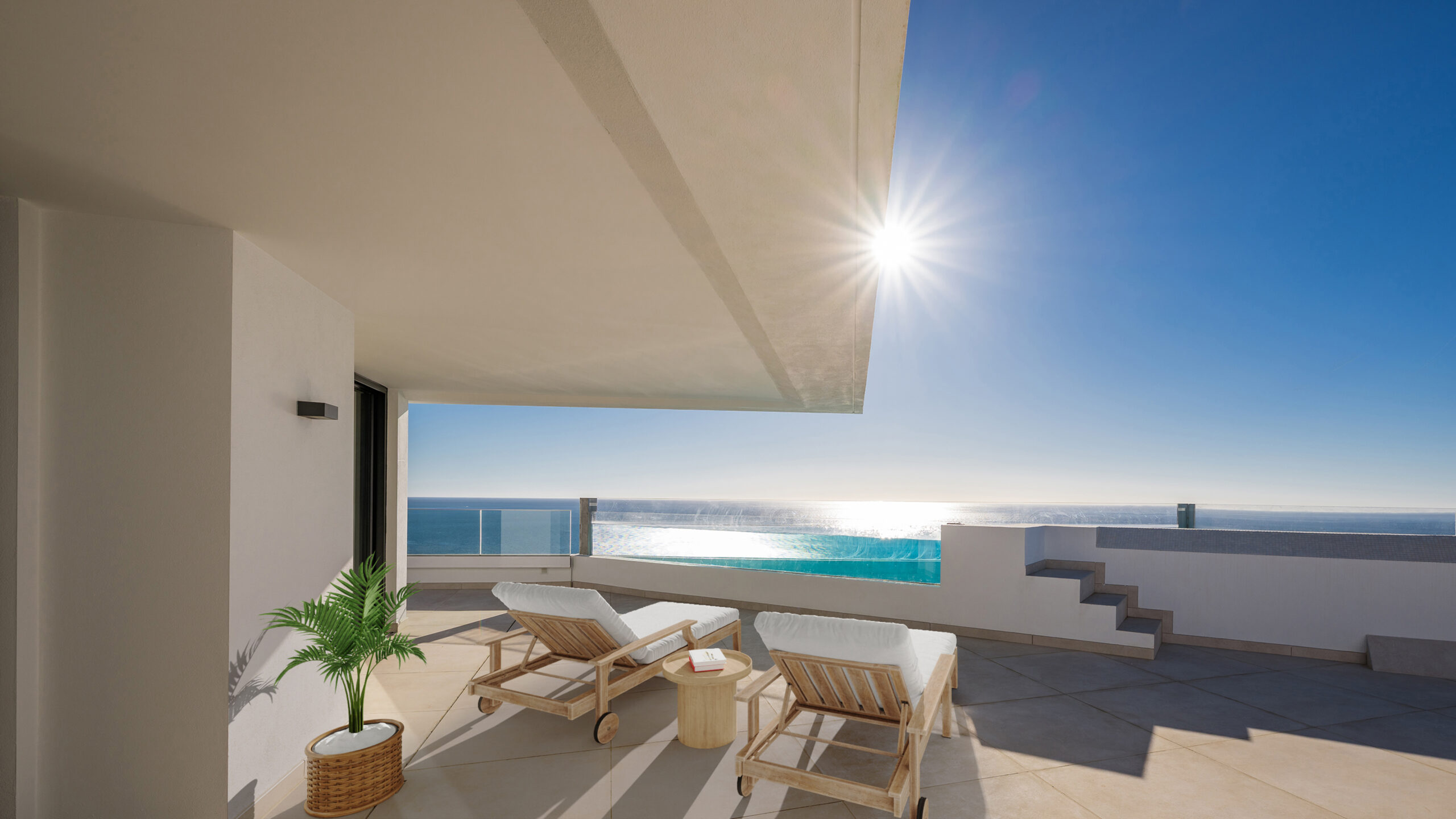 Terraza solárium equipada con tumbonas, con vistas al mar Mediterráneo bajo el sol.