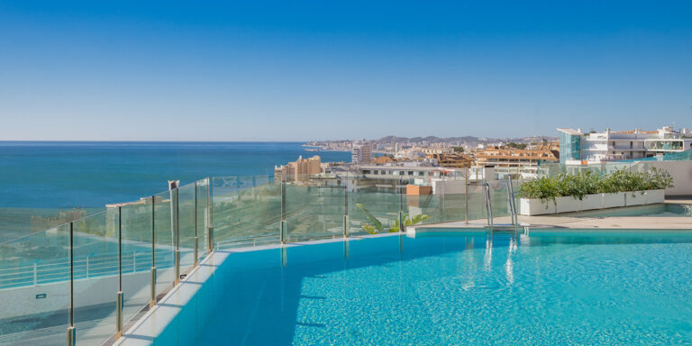 Piscina en una terraza elevada con vistas panorámicas al mar y a la ciudad.
