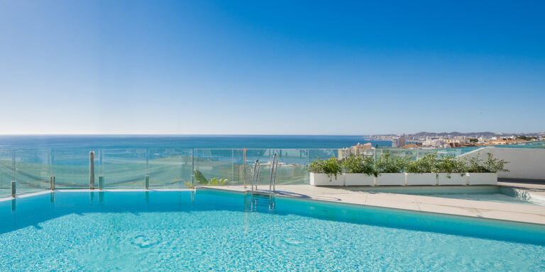 Piscina en amplia terraza luminosa con vista en el mar y en la costa