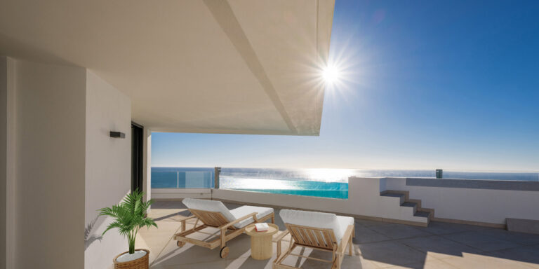 Terraza solárium equipada con tumbonas, con vistas al mar Mediterráneo bajo el sol.