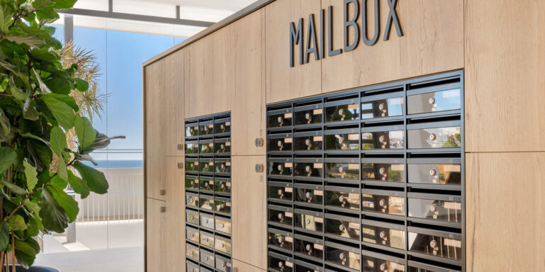 Zona de buzones con acabado en madera en el residencial Carat de RH Privé.